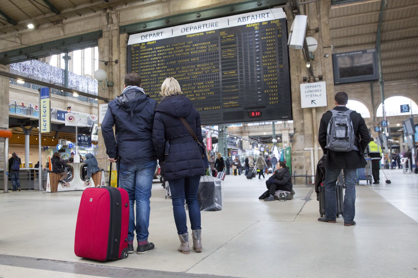 Voyageurs devant le tableau des départs de la gare du Nord